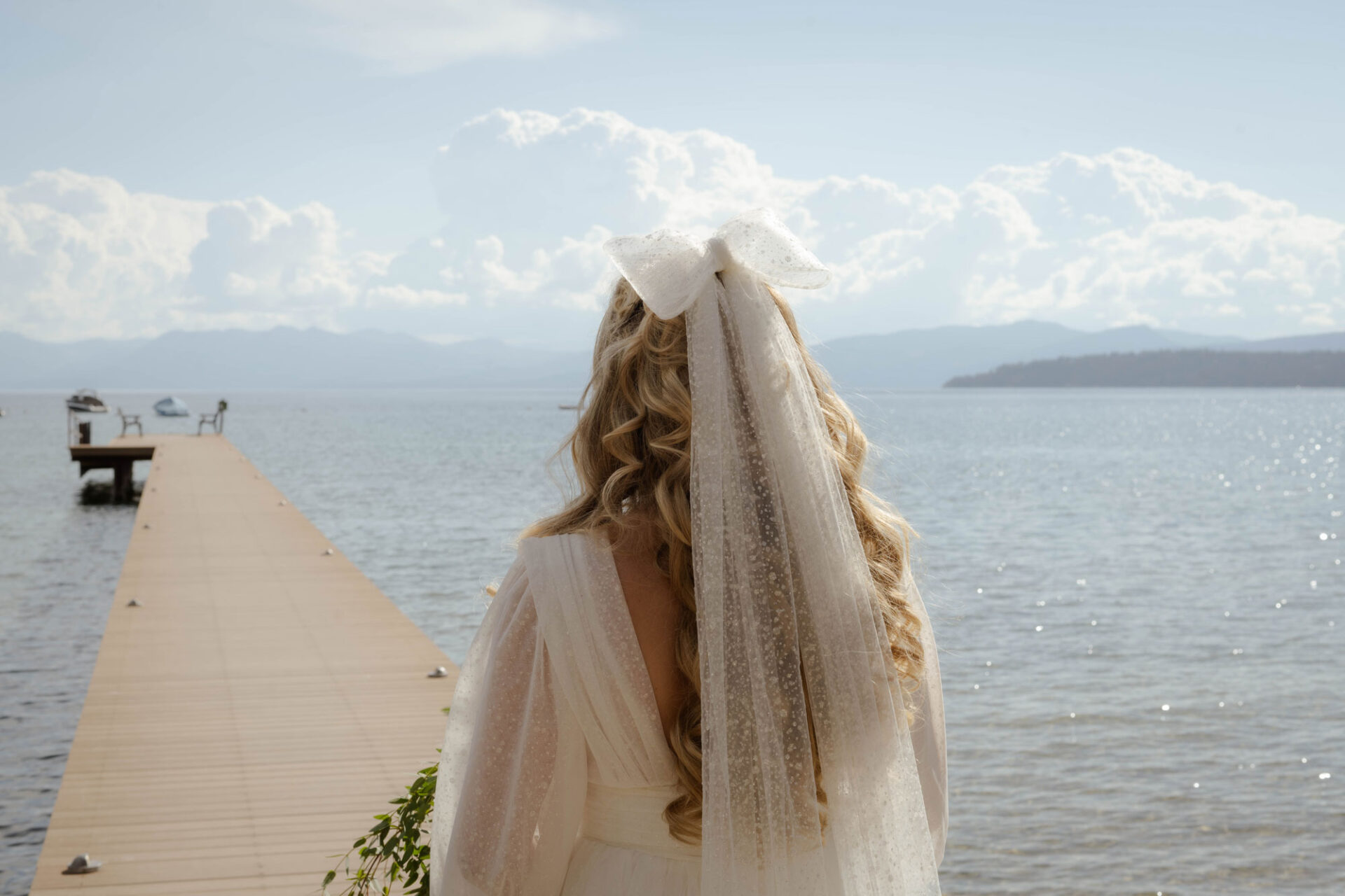 Back of bride's head with veil hanging down and looking toward Lake Tahoe