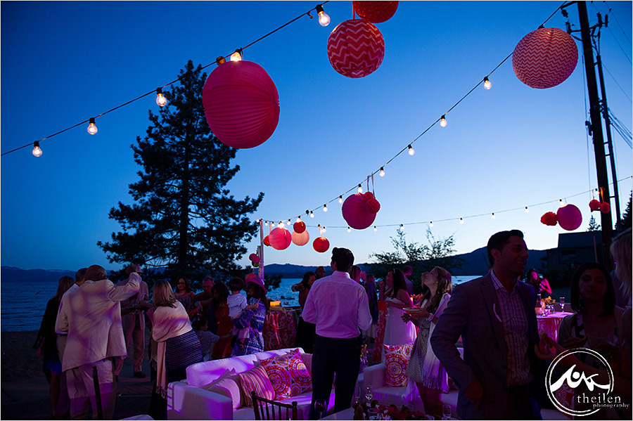 wedding celebration at sunset with beautiful pink and orange decor and market lights strung above