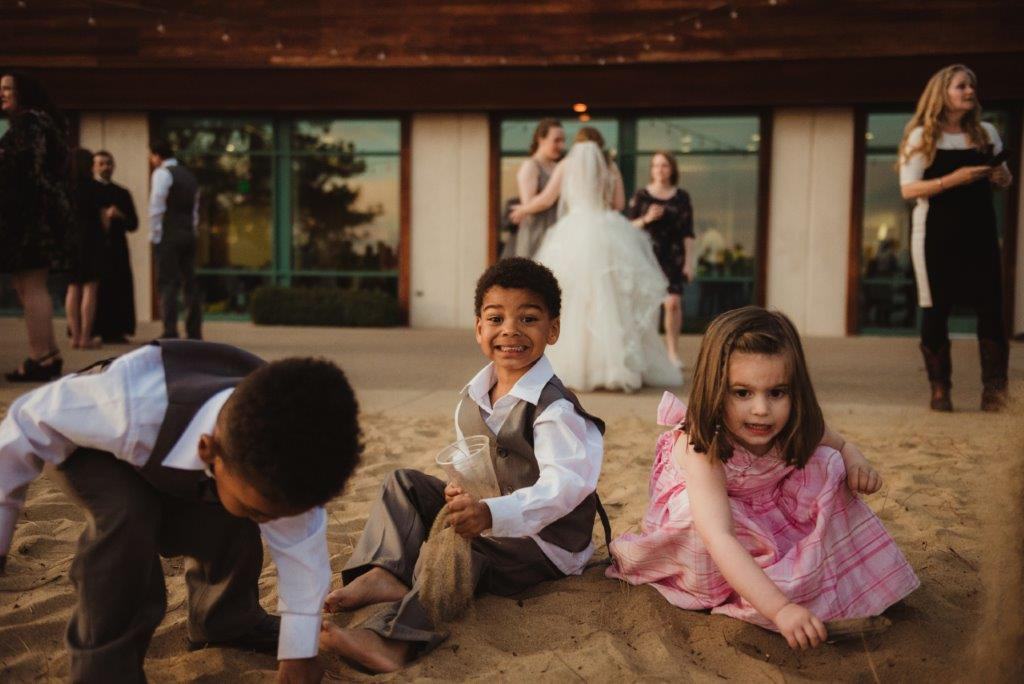 kids playing in the sand on lake tahoe shore at a wedding