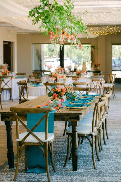 wedding dining room setup with farm table and beautiful teal table runner and napkins