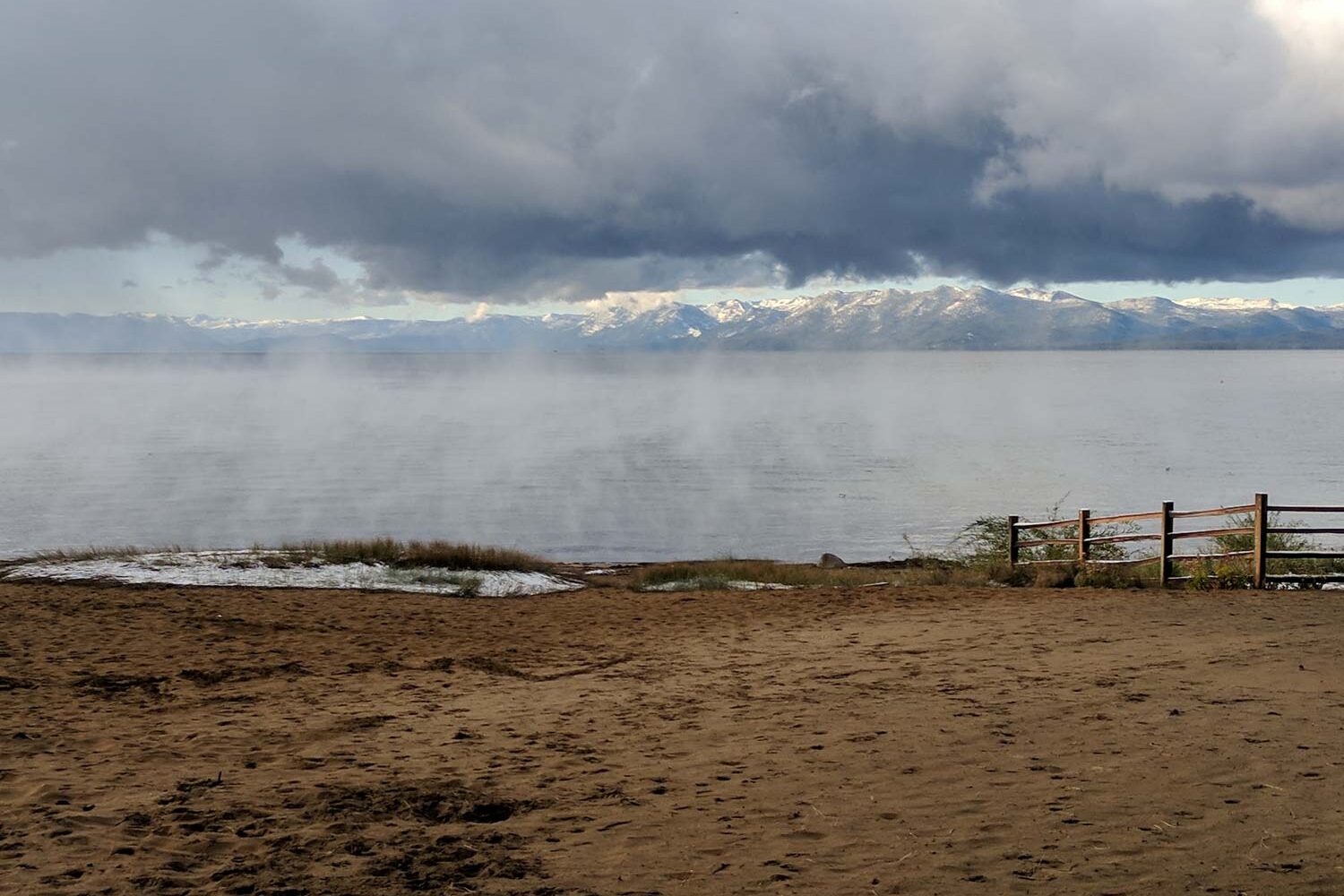 view of lake tahoe on a misty morning with snow capped mountains