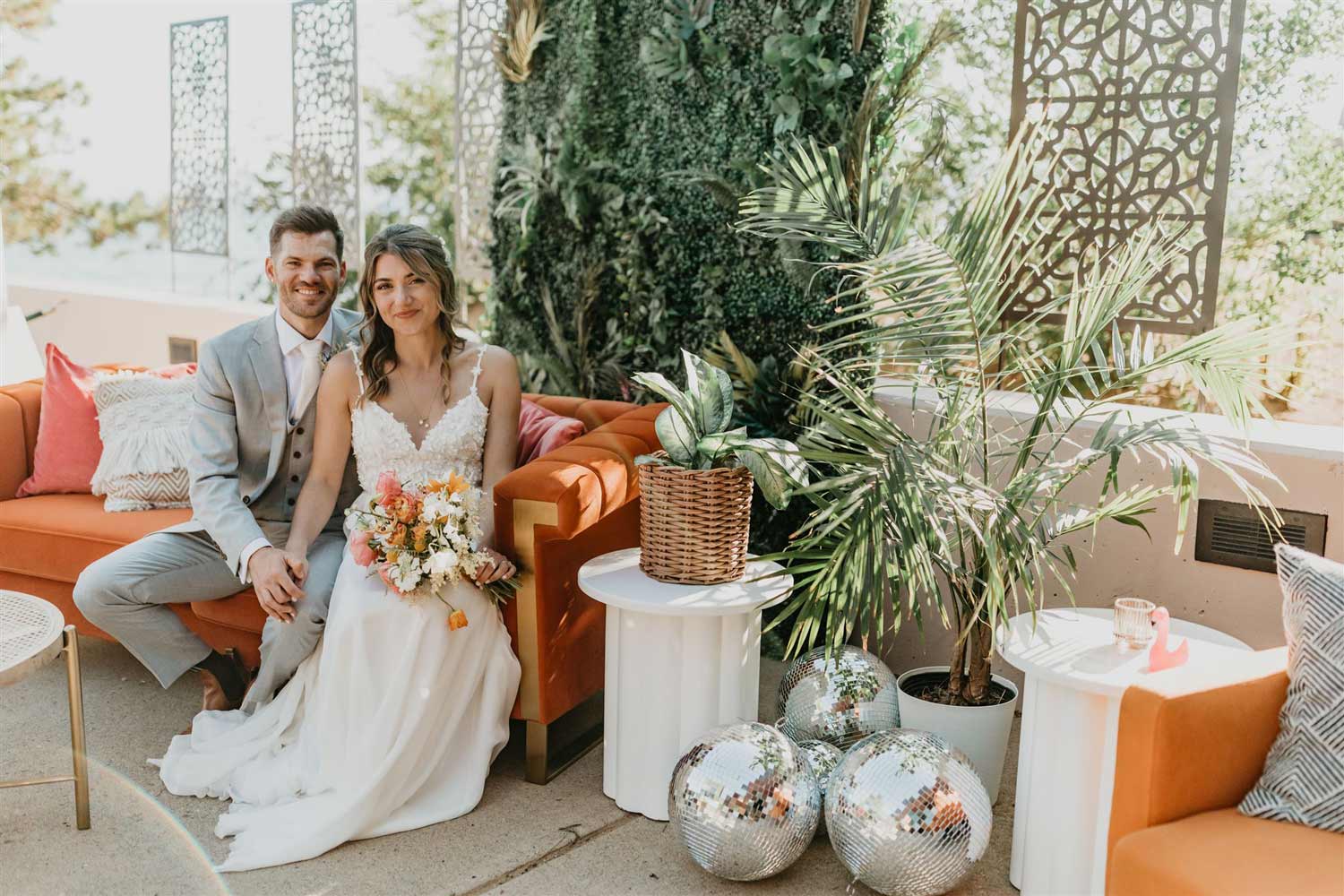 Happy couple sitting in a beautifully decorated outdoor area with warm orange accents