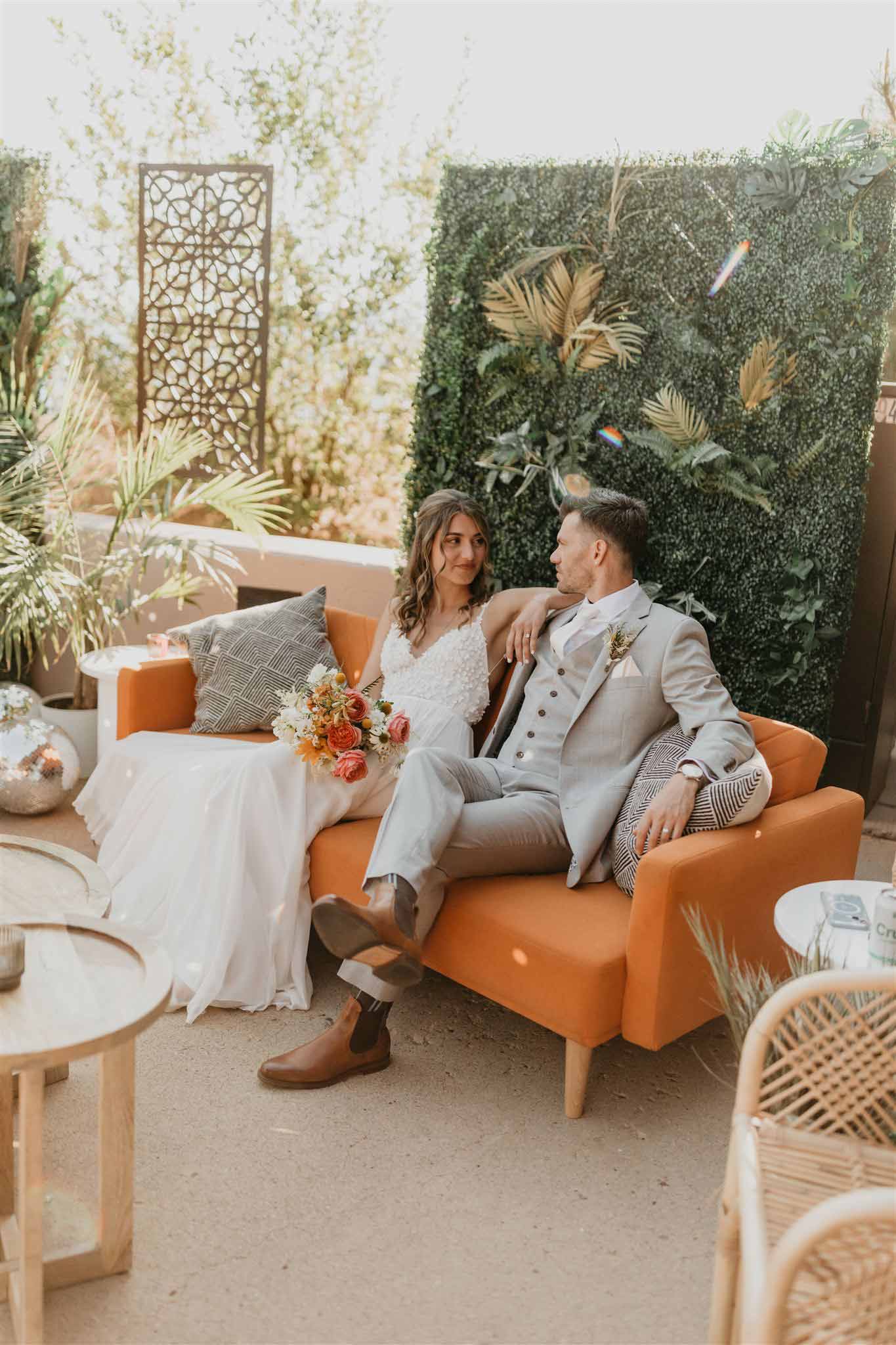 Happy couple looking at each other in a beautifully decorated outdoor area with warm orange accents