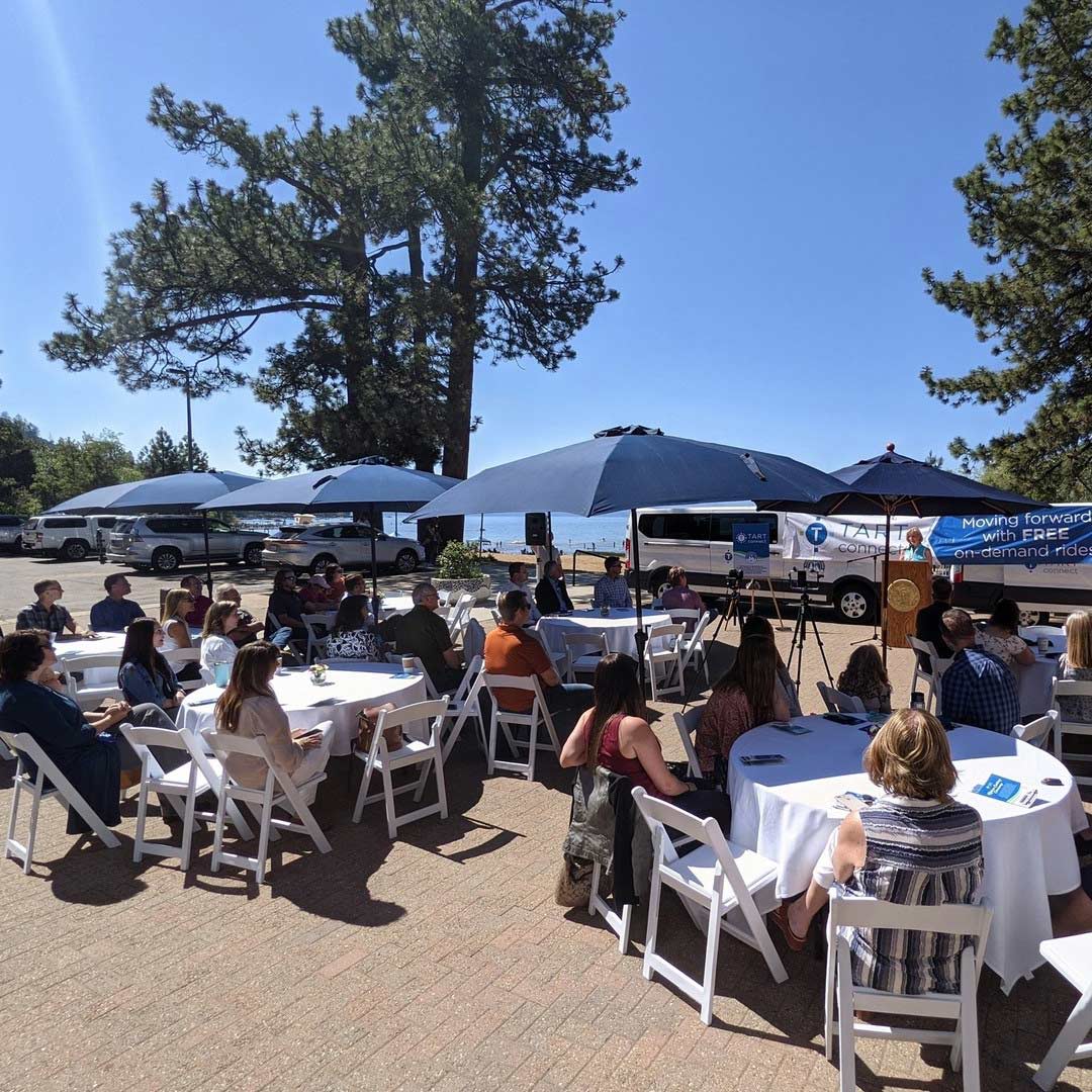 TART meeting at white outdoor tables with navy blue umbrellas beside beautiful Lake Tahoe